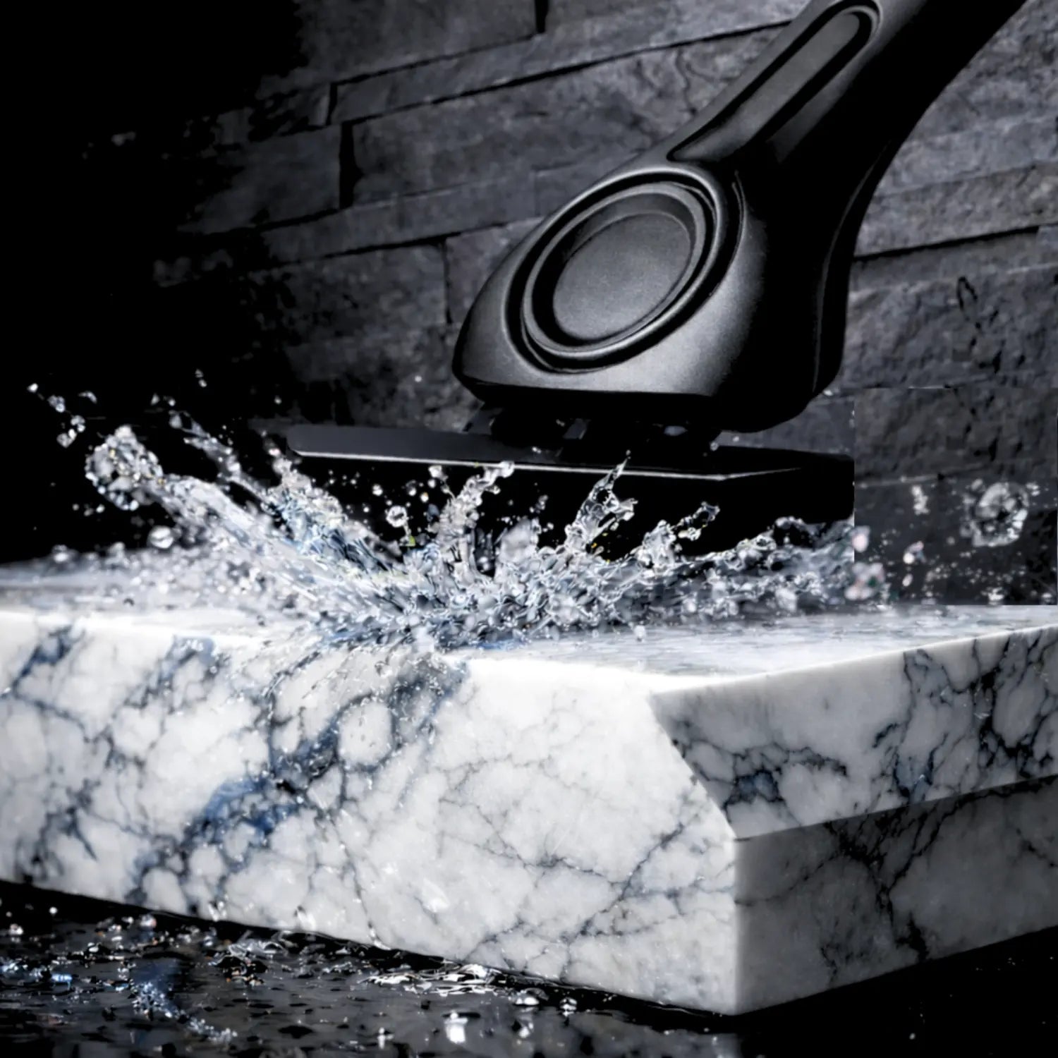 Black metal shaving razor on a marble surface with water splashing around it